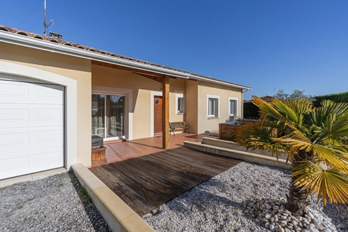 Photo immobilière d'une façade de maison avec vue sur la terrasse.