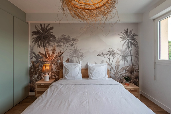Photo d'une chambre avec un lit de place et un papier peint panoramique.